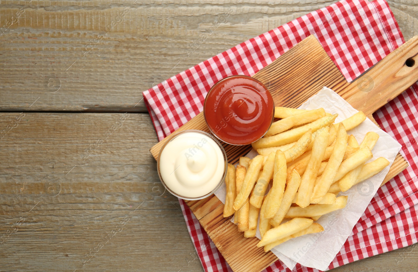Tasty french fries with sauces on wooden table, top view. Space for text Photo of Tasty french fries with sauces on wooden table, top view. Space for text