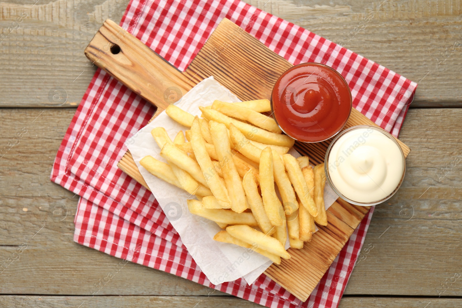 Tasty french fries with sauces on wooden table, top view Photo of Tasty french fries with sauces on wooden table, top view