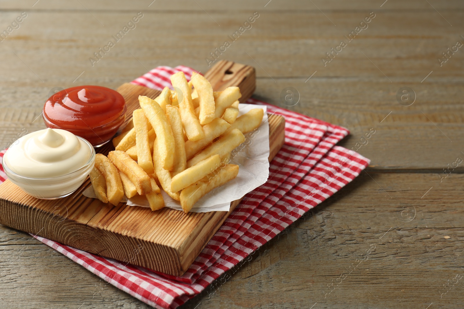 Tasty french fries with sauces on wooden table. Space for text Photo of Tasty french fries with sauces on wooden table. Space for text