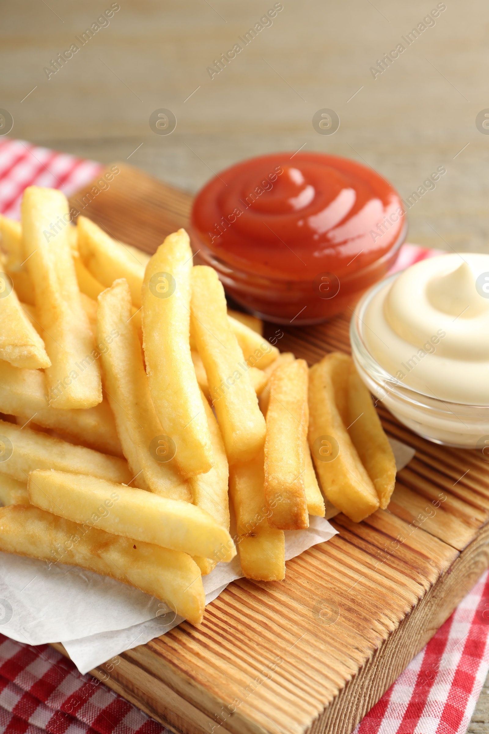 Tasty french fries with sauces on wooden table, closeup Photo of Tasty french fries with sauces on wooden table, closeup