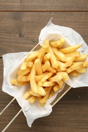 Photo of Tasty french fries on wooden table, top view
