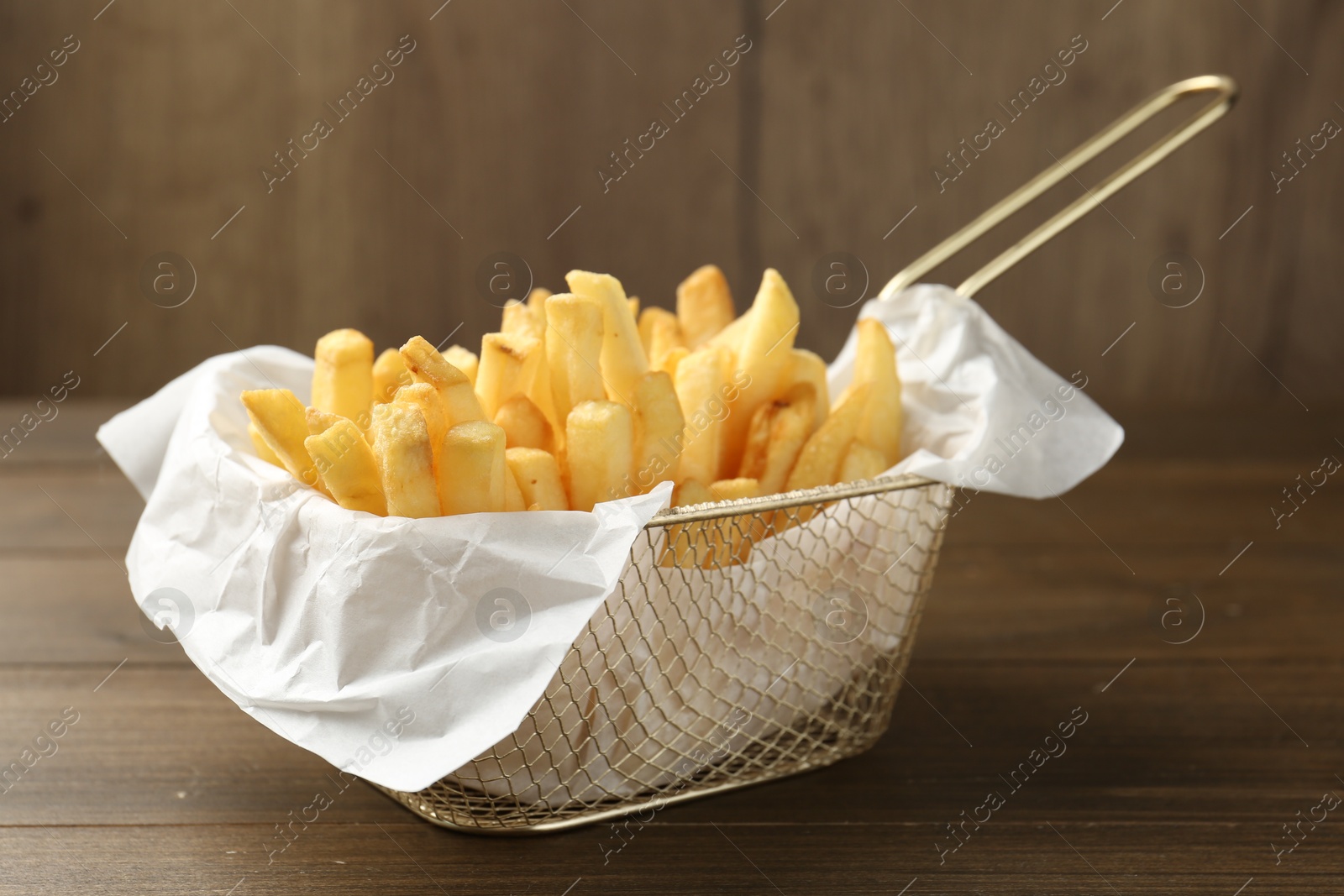 Photo of Tasty french fries on wooden table, closeup