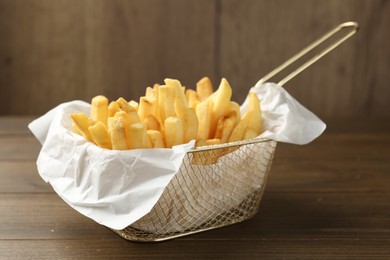 Photo of Tasty french fries on wooden table, closeup
