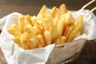 Photo of Tasty french fries on wooden table, closeup