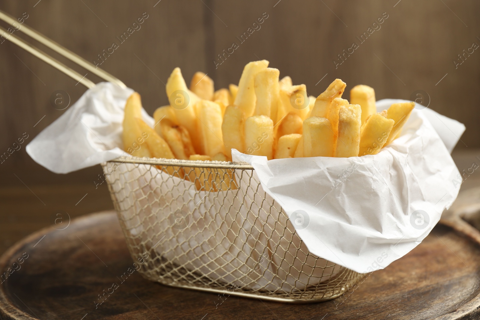 Tasty french fries on wooden table, closeup Photo of Tasty french fries on wooden table, closeup