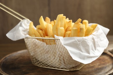 Photo of Tasty french fries on wooden table, closeup