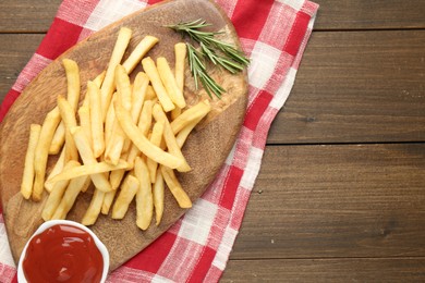 Photo of Tasty french fries with ketchup and rosemary on wooden table, top view. Space for text