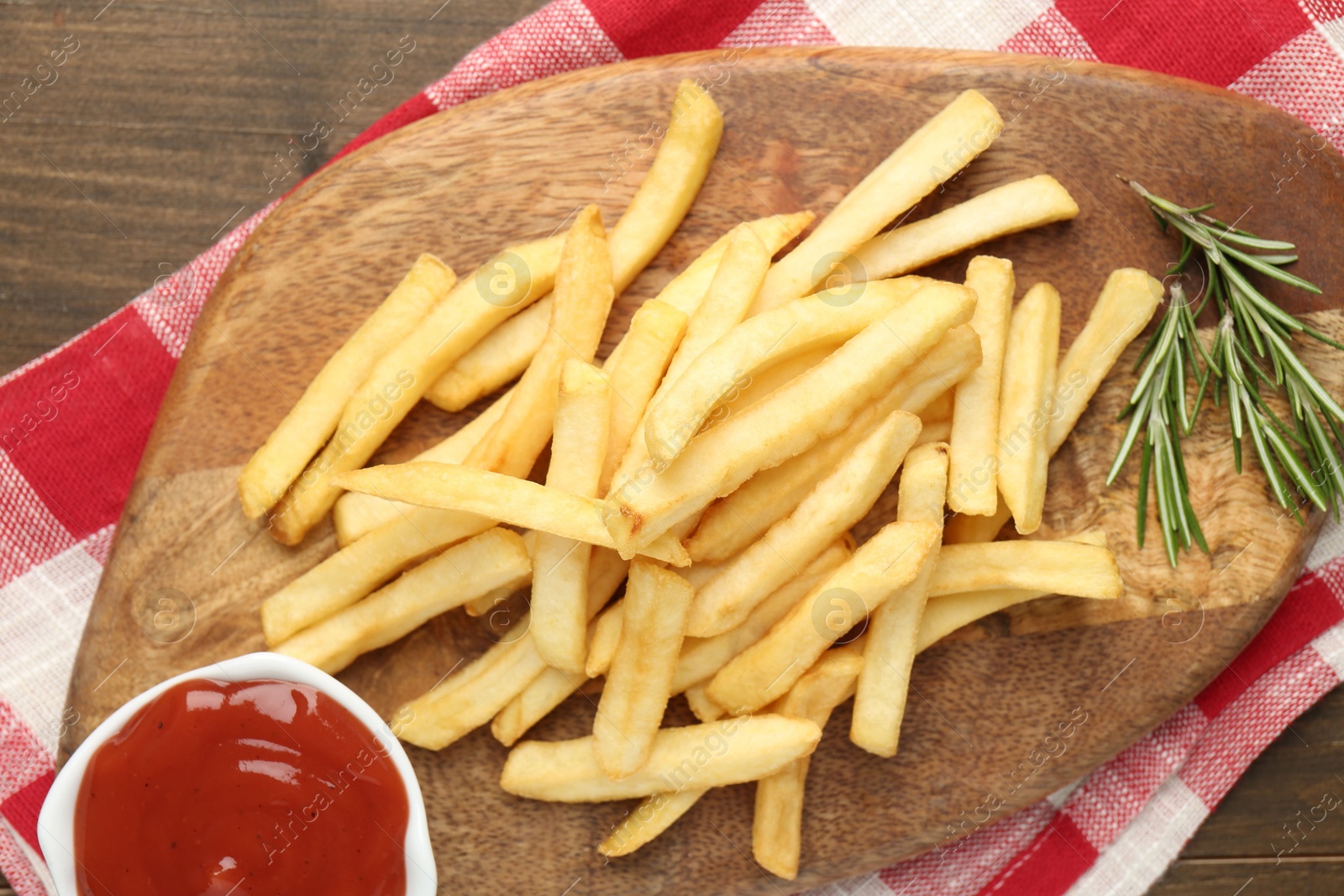 Tasty french fries with ketchup and rosemary on wooden table, top view Photo of Tasty french fries with ketchup and rosemary on wooden table, top view