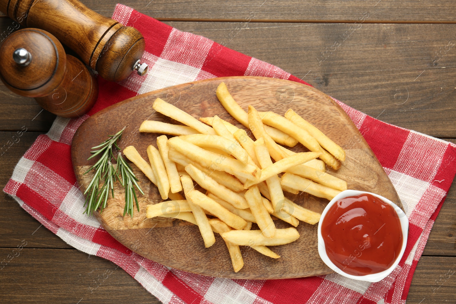 Tasty french fries with ketchup and rosemary on wooden table, top view Photo of Tasty french fries with ketchup and rosemary on wooden table, top view
