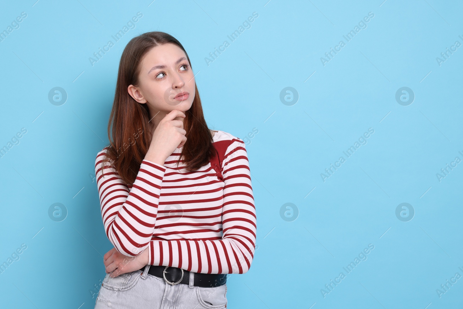 Portrait of teenage girl on light blue background, space for text Photo of Portrait of teenage girl on light blue background, space for text