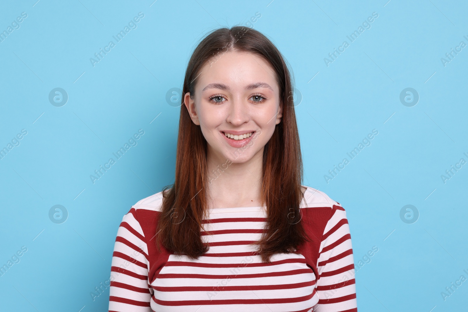 Photo of Portrait of happy teenage girl on light blue background