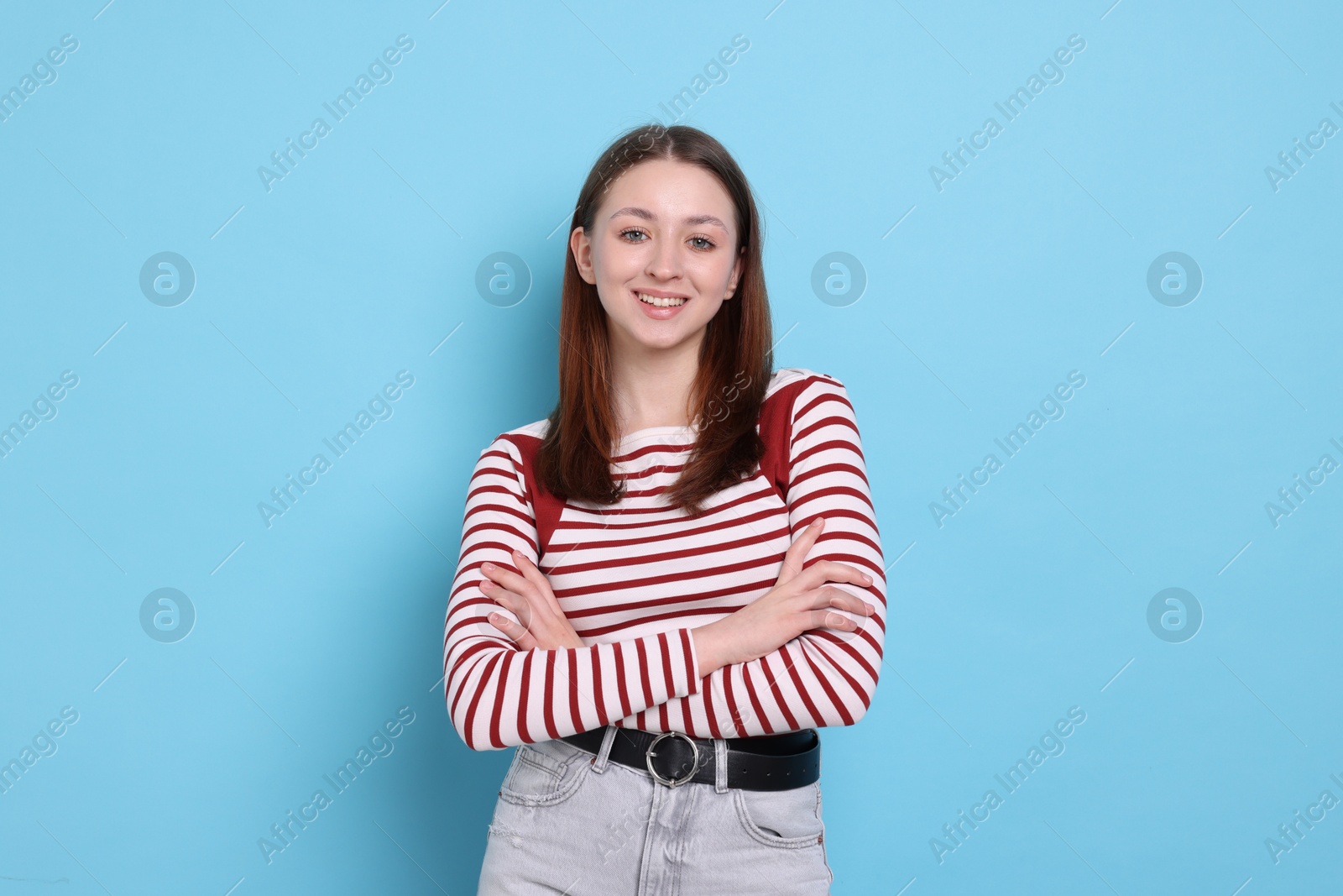 Photo of Portrait of happy teenage girl on light blue background
