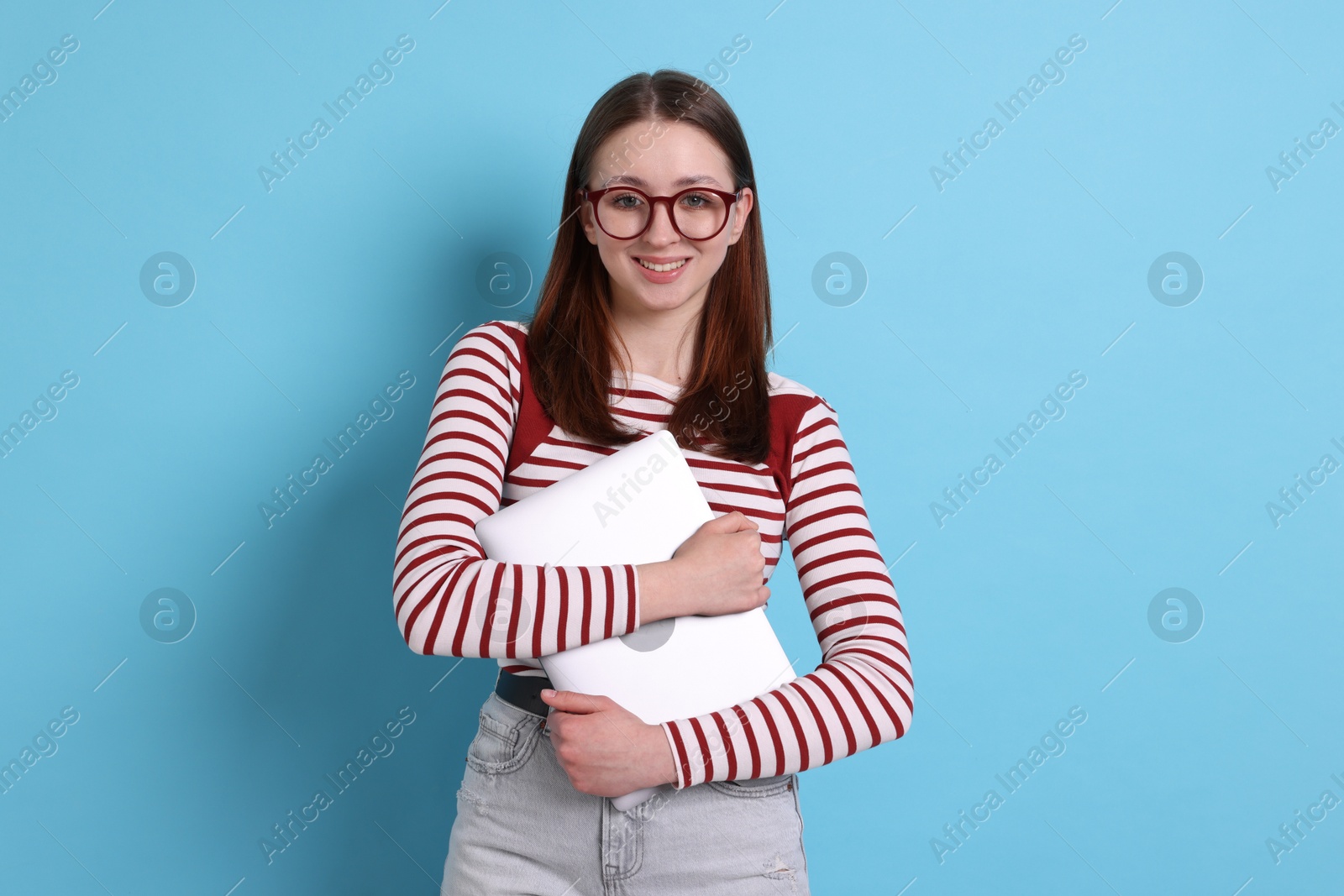 Photo of Teenage girl with laptop on light blue background