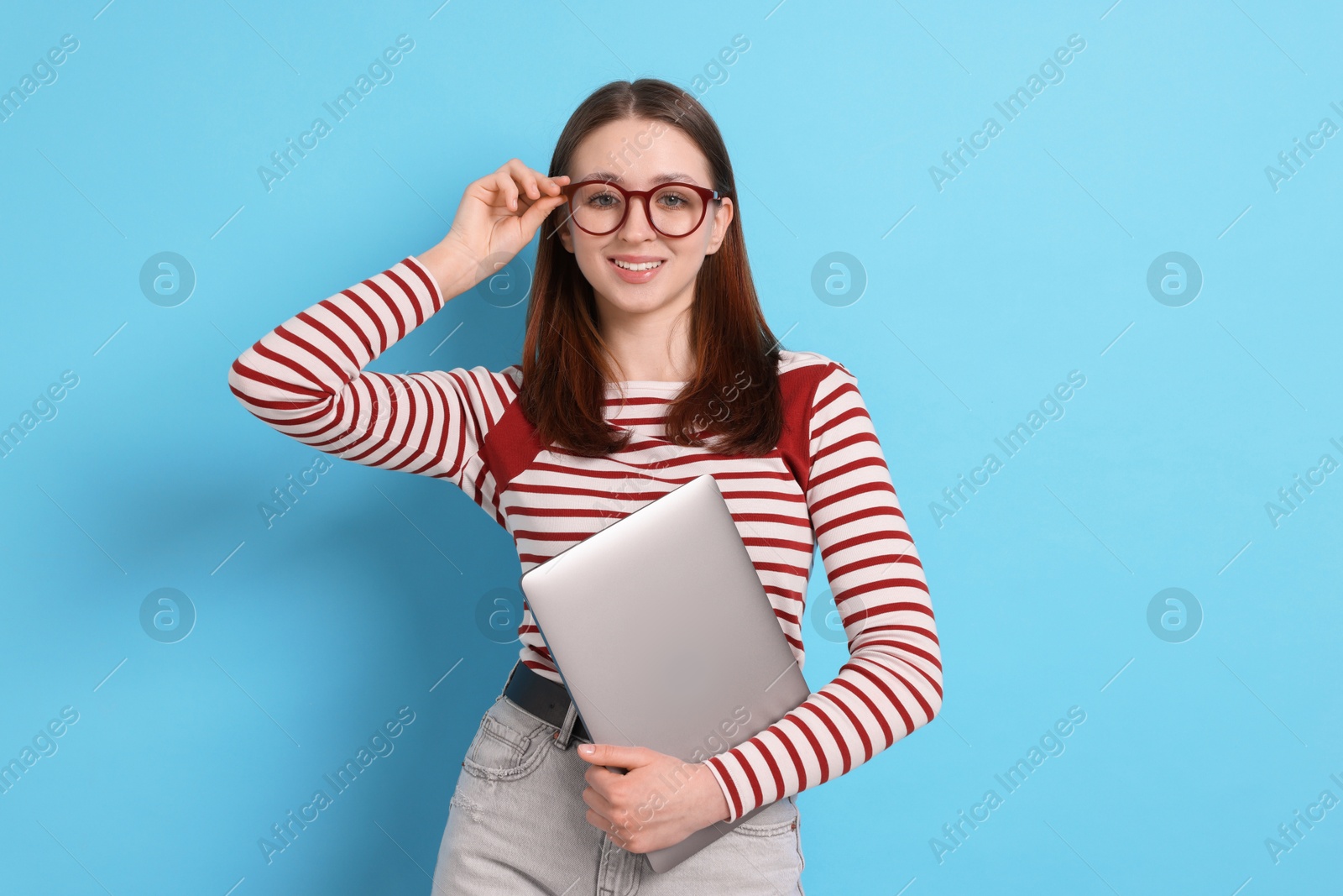 Photo of Teenage girl with laptop on light blue background