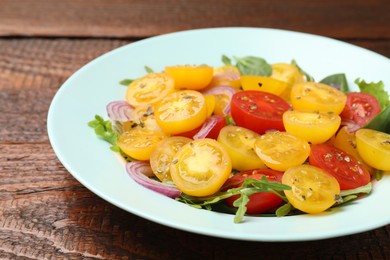 Photo of Fresh salad with yellow tomatoes on wooden table, closeup