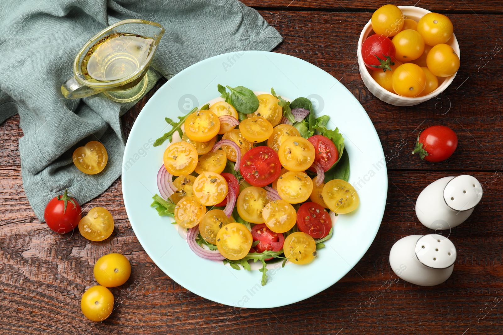 Fresh salad with yellow tomatoes served on wooden table, flat lay Photo of Fresh salad with yellow tomatoes served on wooden table, flat lay