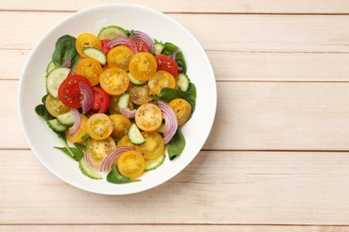 Photo of Fresh salad with yellow tomatoes on wooden table, top view. Space for text