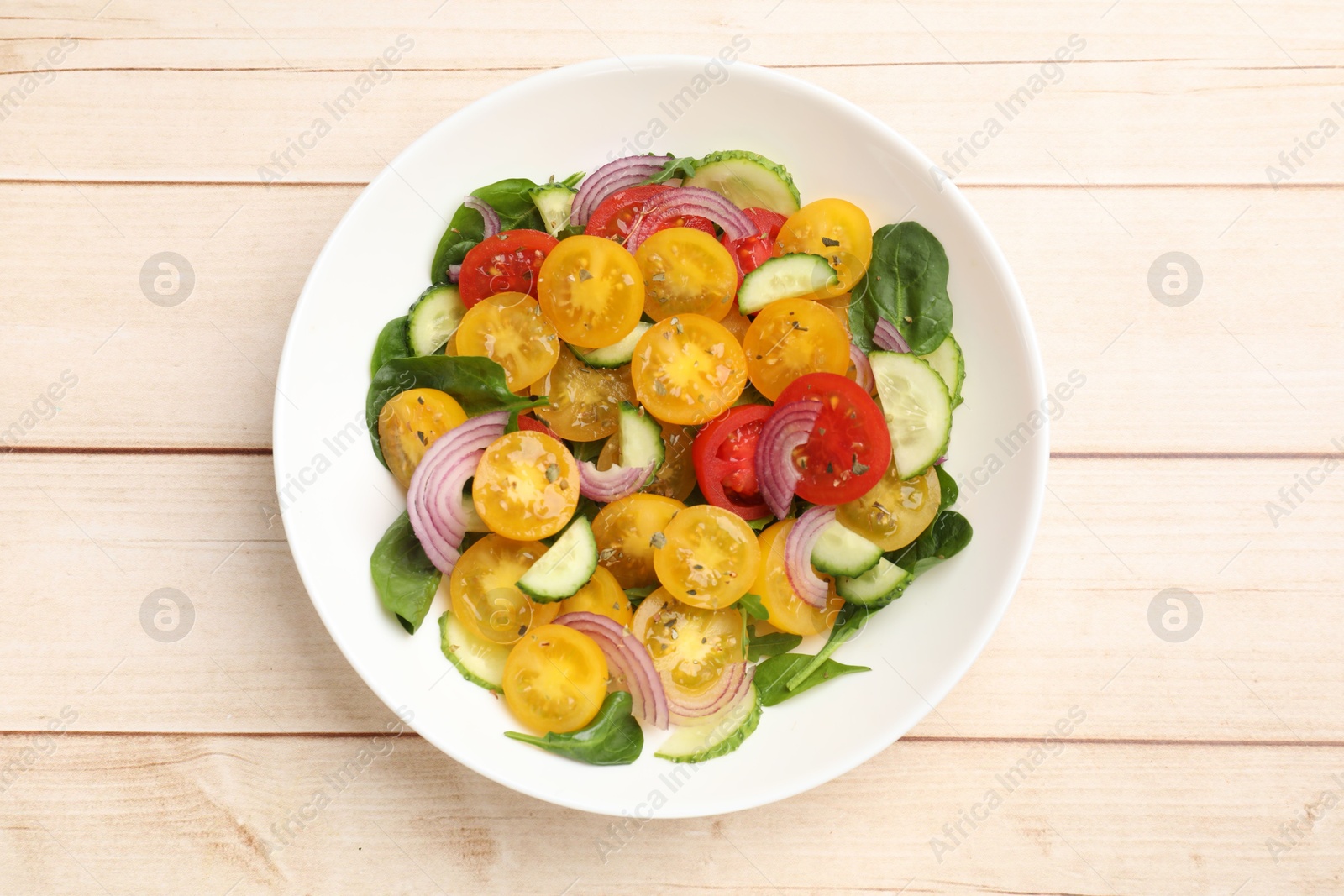 Fresh salad with yellow tomatoes on wooden table, top view Photo of Fresh salad with yellow tomatoes on wooden table, top view