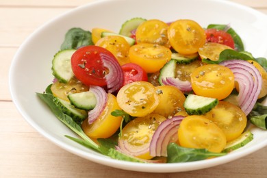 Photo of Fresh salad with yellow tomatoes on wooden table, closeup