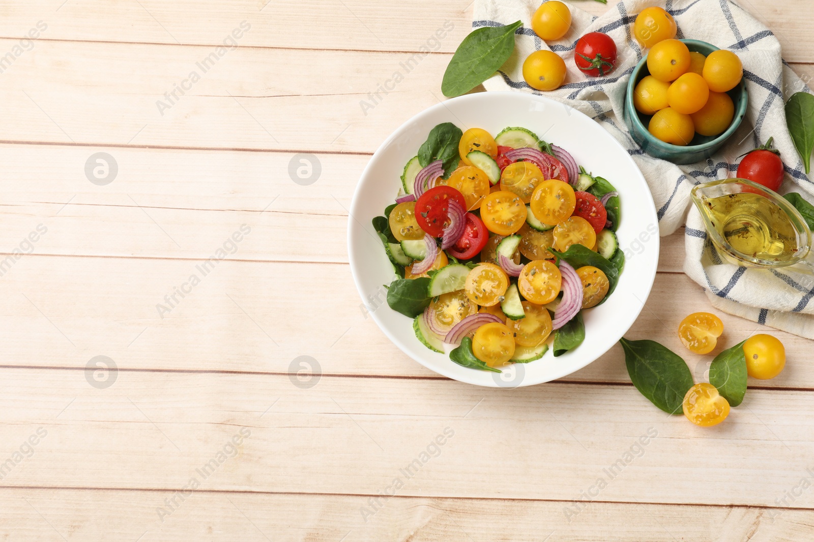 Fresh salad with yellow tomatoes served on wooden table, flat lay. Space for text Photo of Fresh salad with yellow tomatoes served on wooden table, flat lay. Space for text