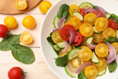 Photo of Fresh salad with yellow tomatoes served on wooden table, flat lay