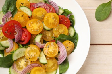 Photo of Fresh salad with yellow tomatoes on wooden table, top view