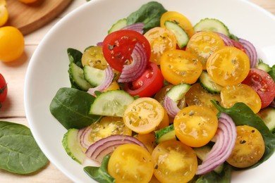 Photo of Fresh salad with yellow tomatoes on table, closeup