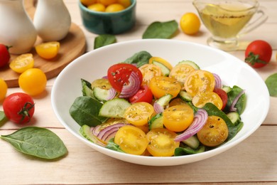 Photo of Fresh salad with yellow tomatoes served on wooden table, closeup