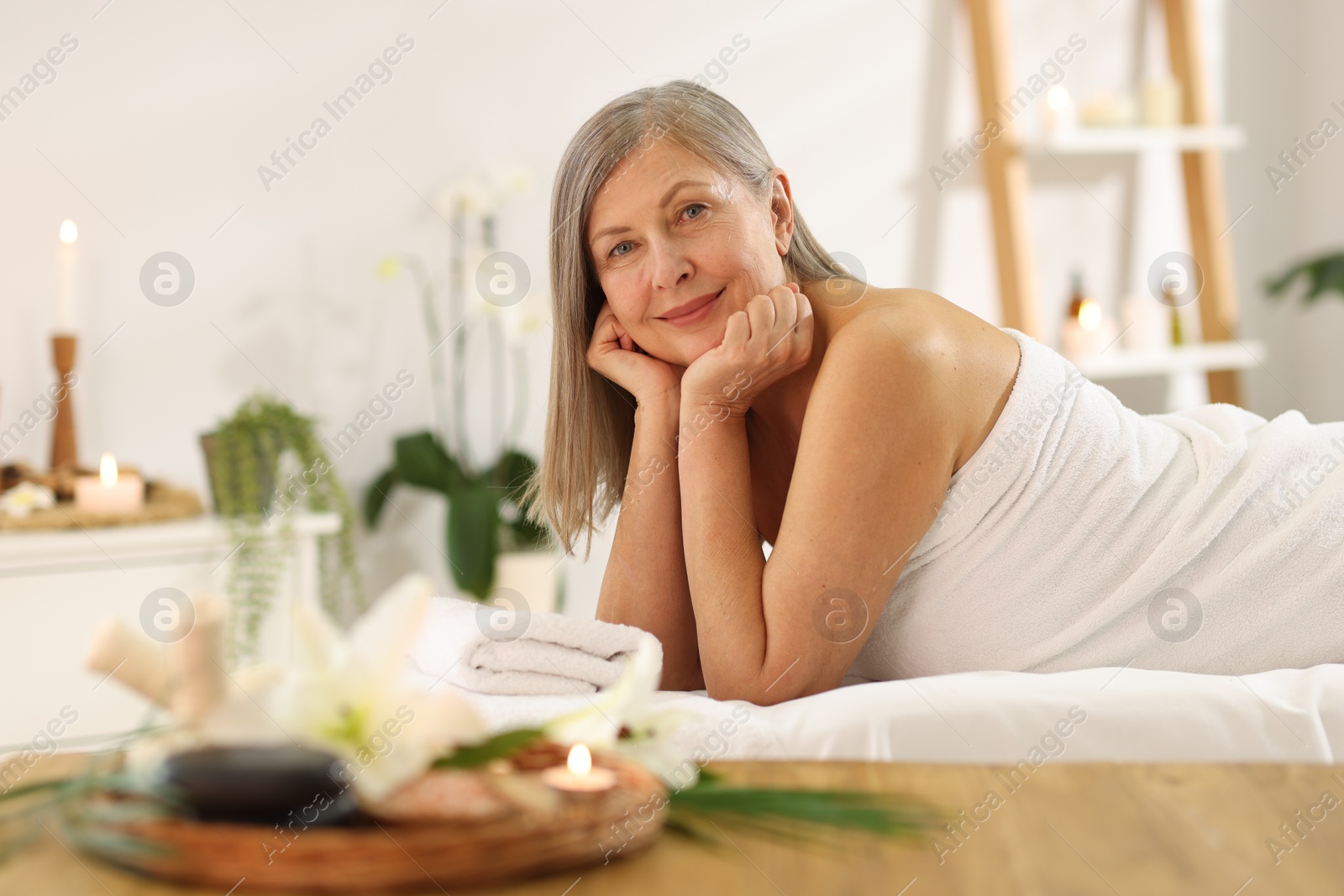 Senior woman relaxing on massage couch in spa salon Photo of Senior woman relaxing on massage couch in spa salon