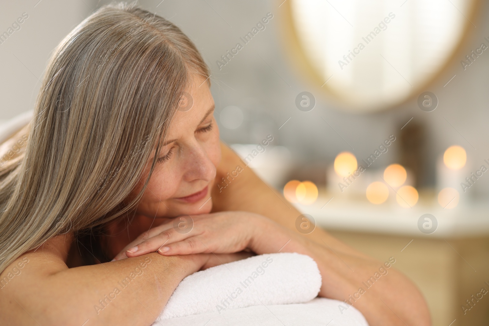 Senior woman relaxing on massage couch in spa salon Photo of Senior woman relaxing on massage couch in spa salon