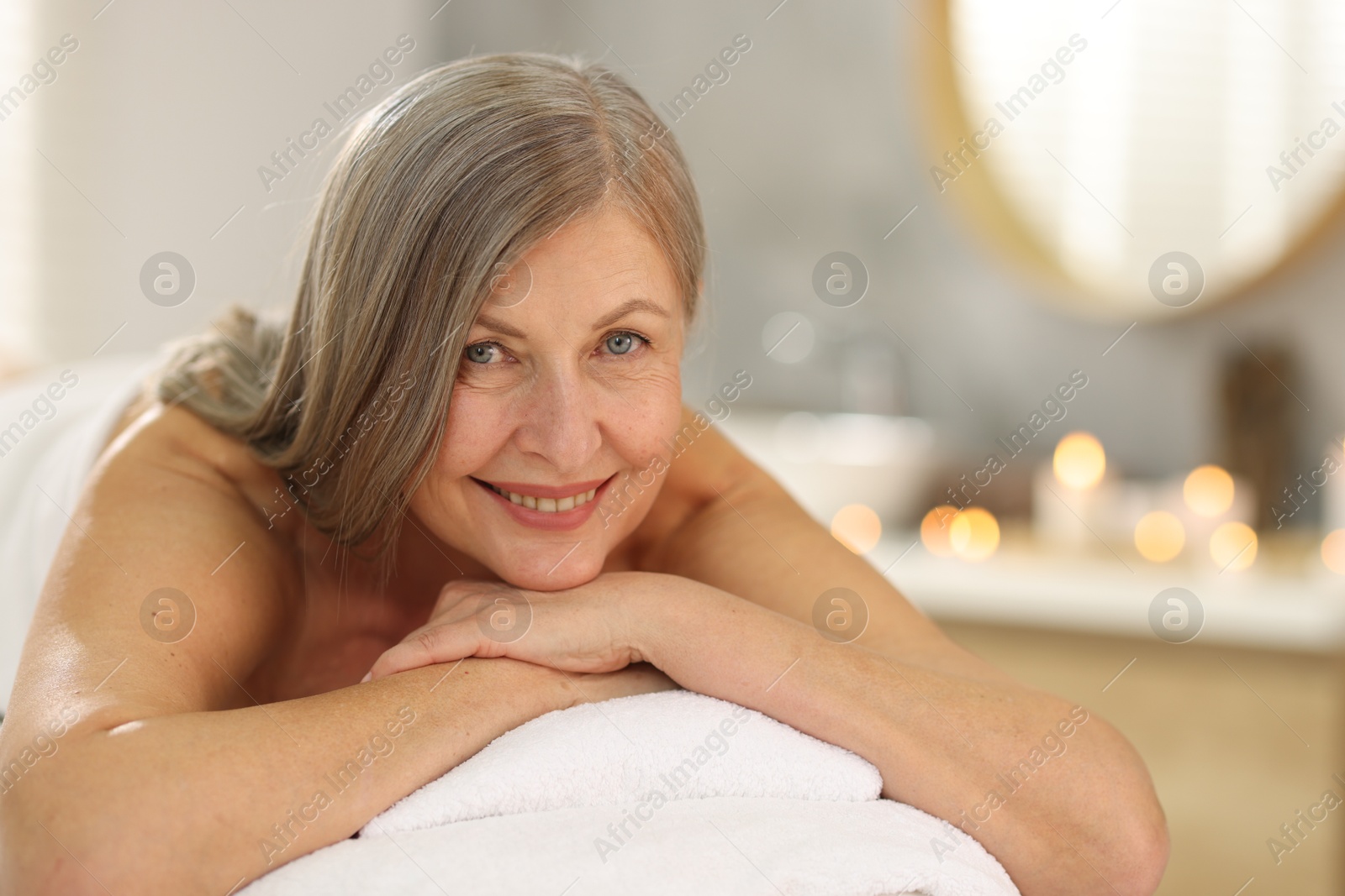 Senior woman relaxing on massage couch in spa salon Photo of Senior woman relaxing on massage couch in spa salon