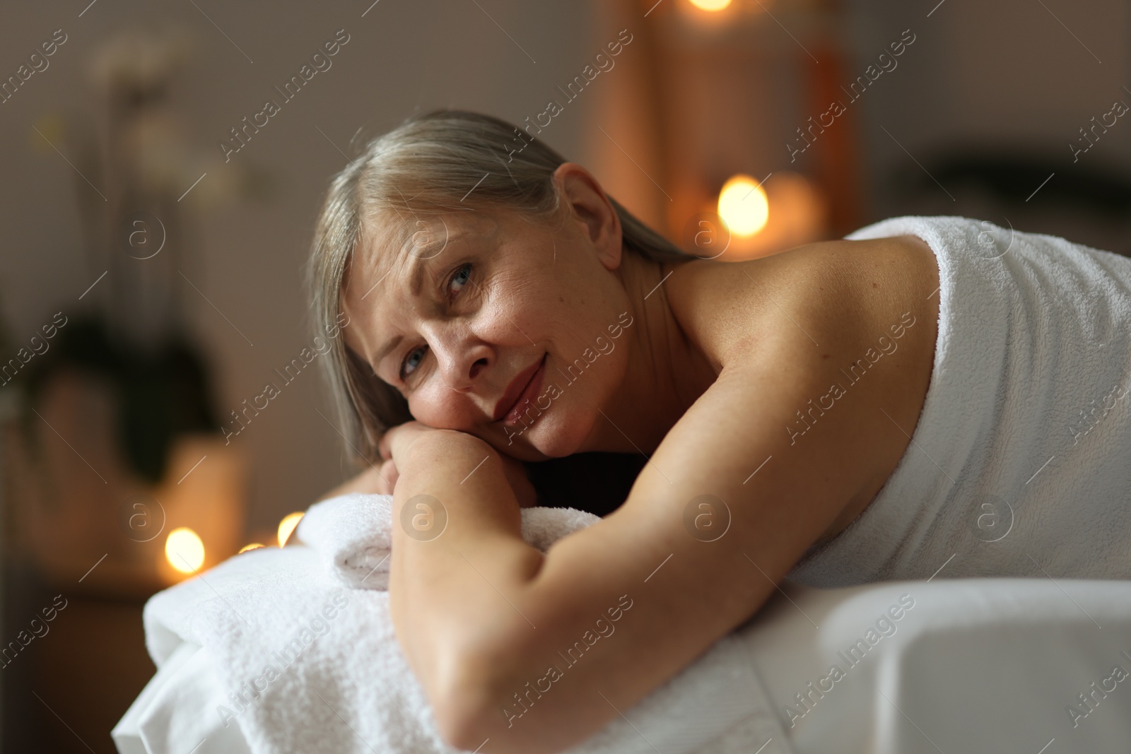 Senior woman relaxing on massage couch in spa salon Photo of Senior woman relaxing on massage couch in spa salon