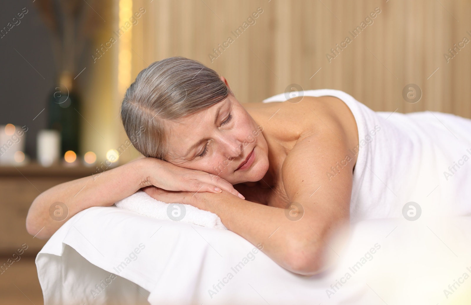 Senior woman relaxing on massage couch in spa salon Photo of Senior woman relaxing on massage couch in spa salon