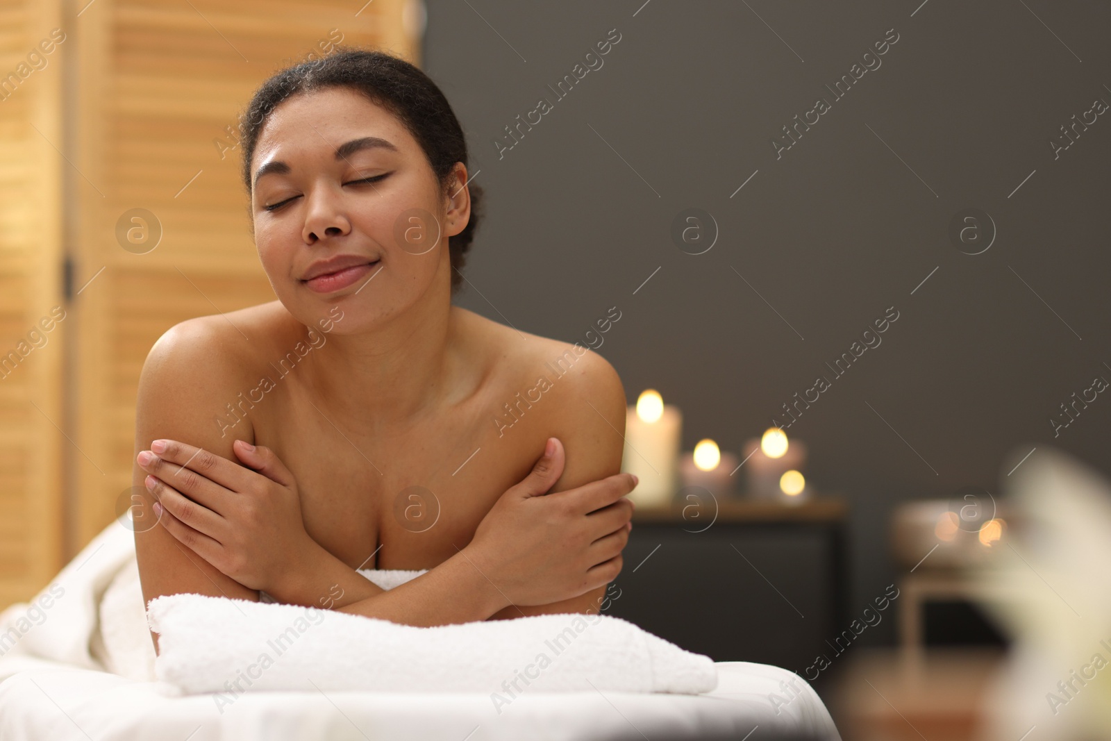 Beautiful woman relaxing on massage couch in spa salon, space for text Photo of Beautiful woman relaxing on massage couch in spa salon, space for text