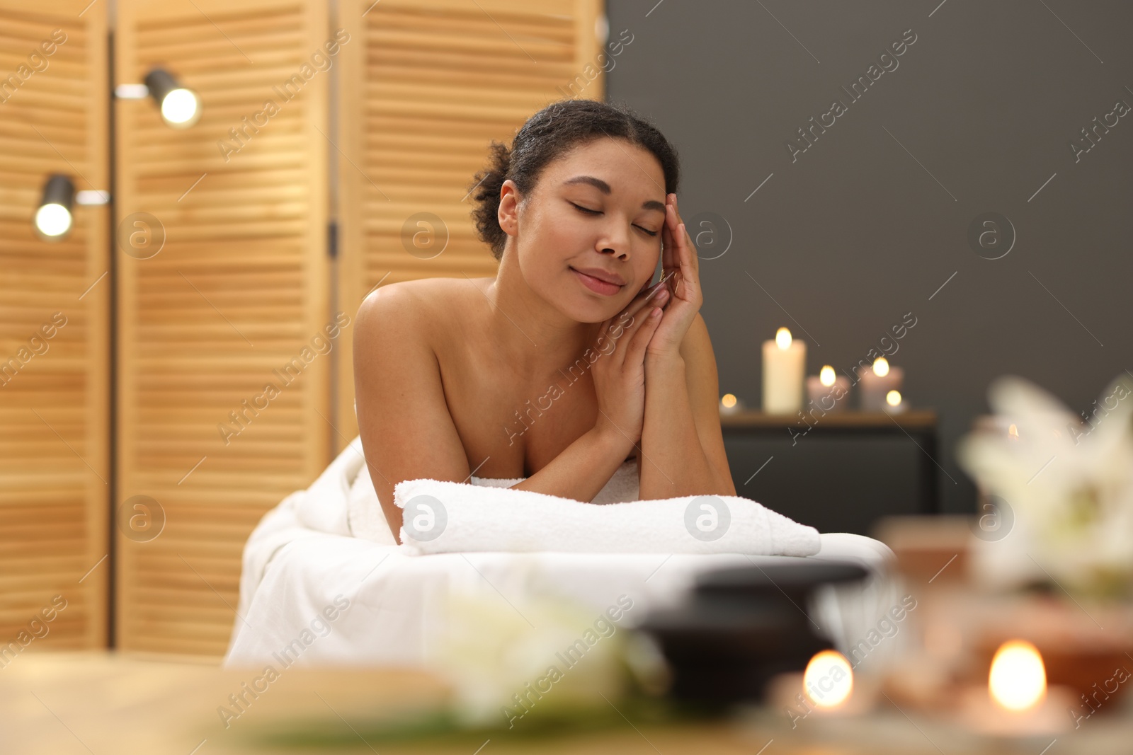 Beautiful woman relaxing on massage couch in spa salon Photo of Beautiful woman relaxing on massage couch in spa salon