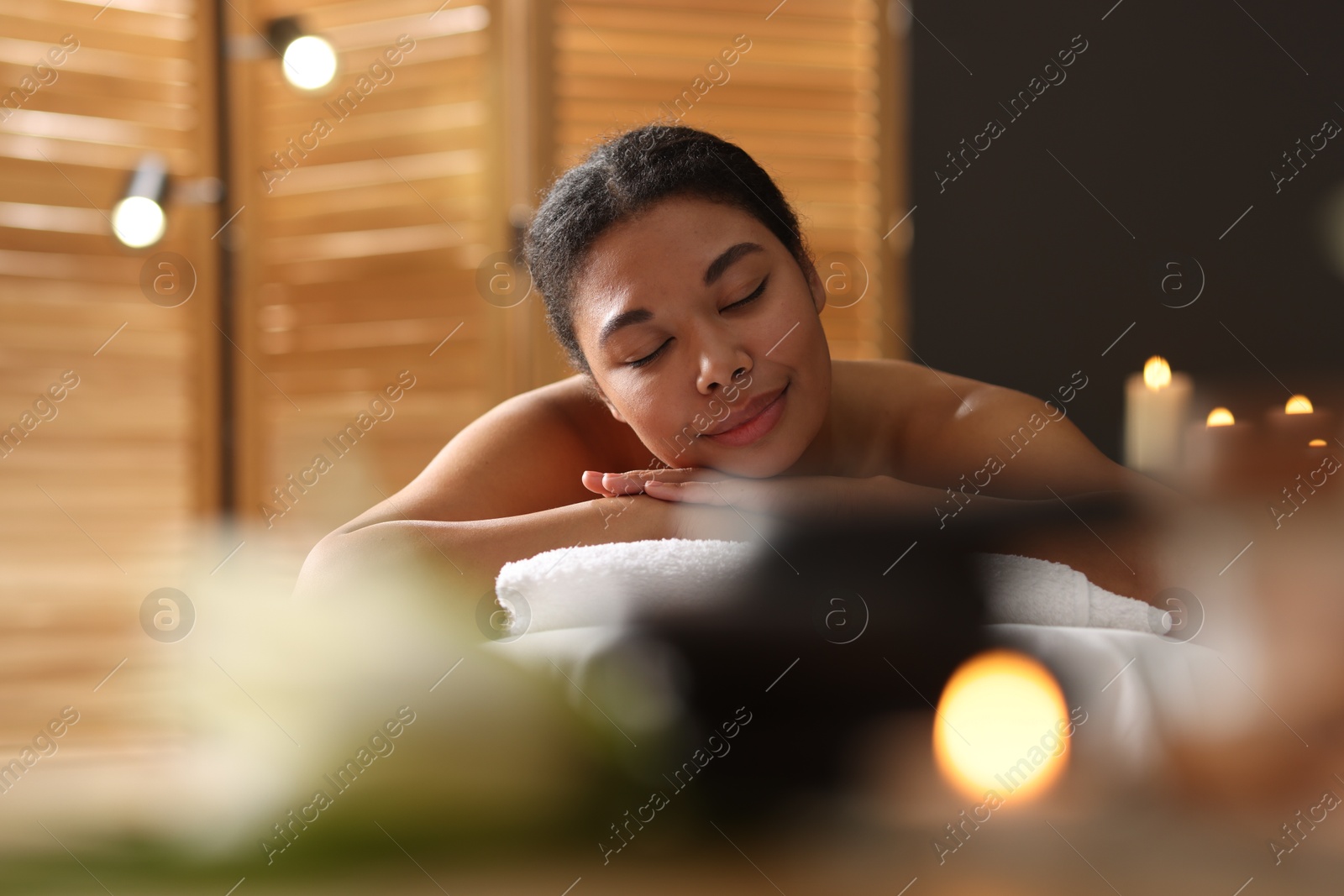 Beautiful woman relaxing on massage couch in spa salon Photo of Beautiful woman relaxing on massage couch in spa salon