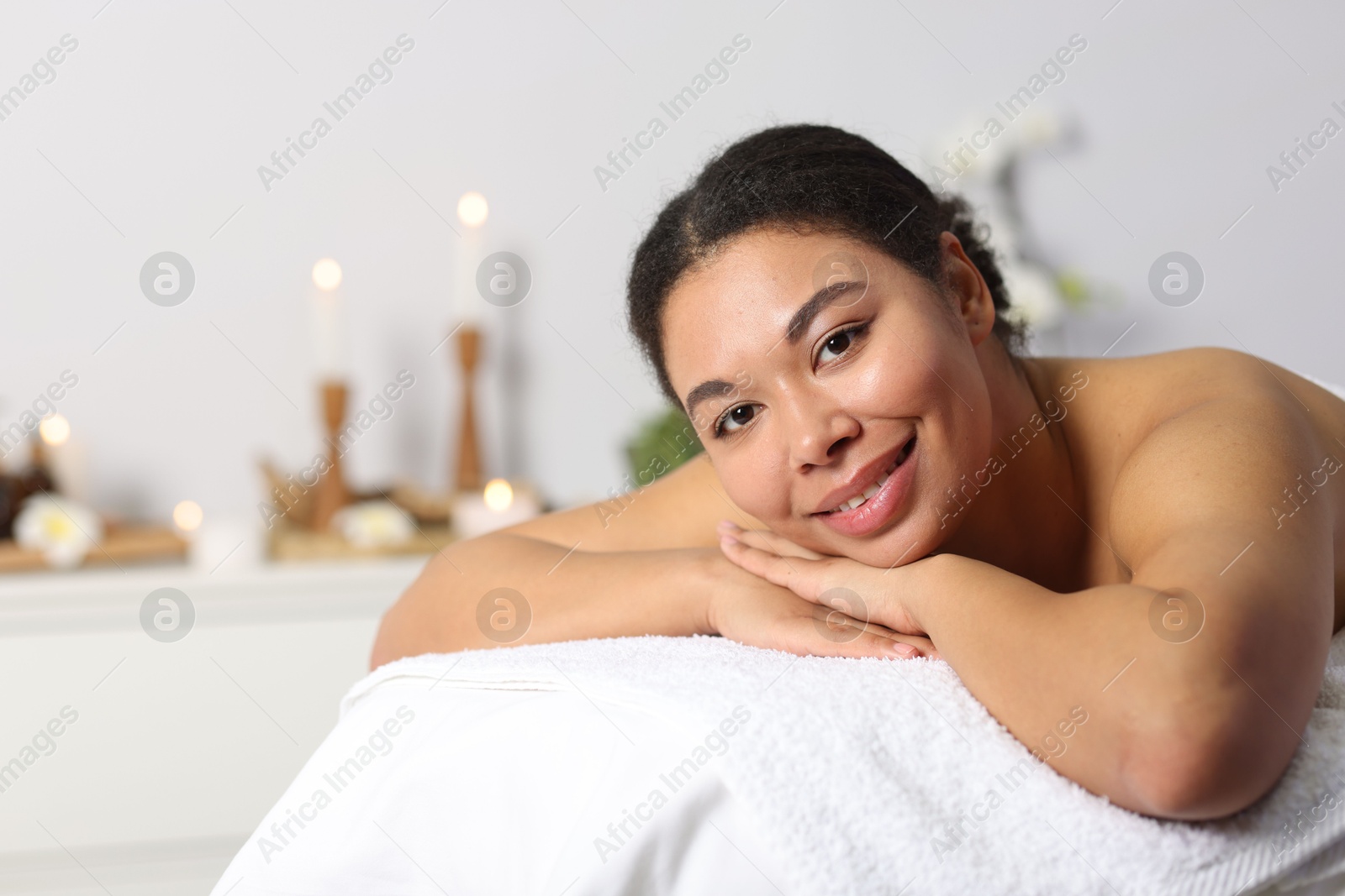 Beautiful woman relaxing on massage couch in spa salon, space for text Photo of Beautiful woman relaxing on massage couch in spa salon, space for text