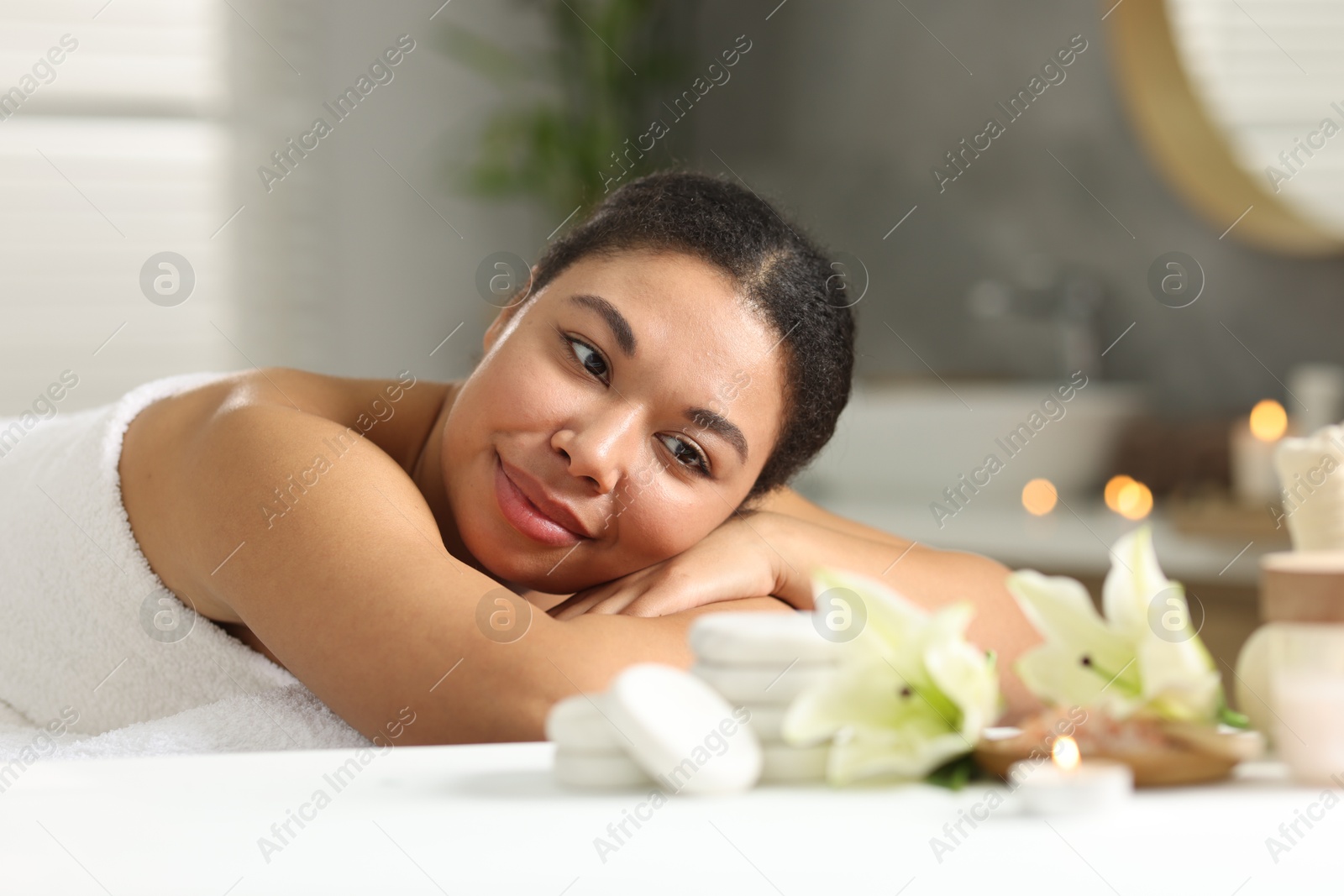 Beautiful woman relaxing on massage couch in spa salon Photo of Beautiful woman relaxing on massage couch in spa salon