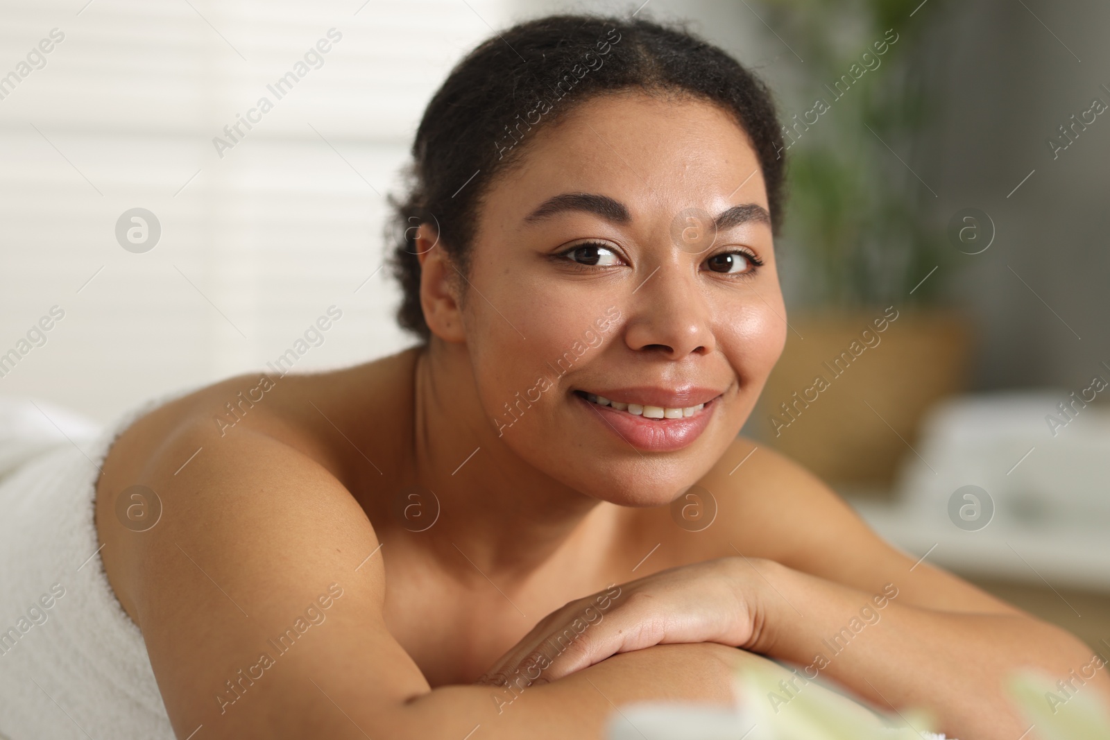 Beautiful woman relaxing on massage couch in spa salon Photo of Beautiful woman relaxing on massage couch in spa salon