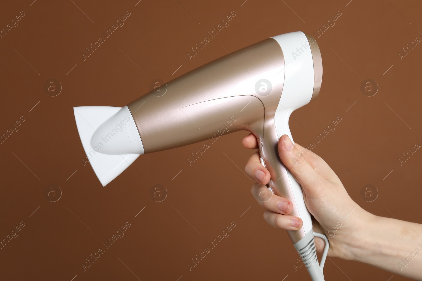 Woman with hair dryer on brown background, closeup Photo of Woman with hair dryer on brown background, closeup