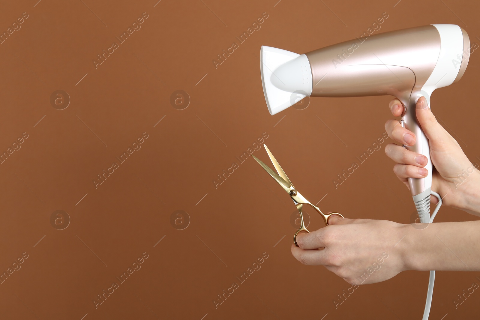 Woman with hair dryer and scissors on brown background, closeup. Space for text Photo of Woman with hair dryer and scissors on brown background, closeup. Space for text
