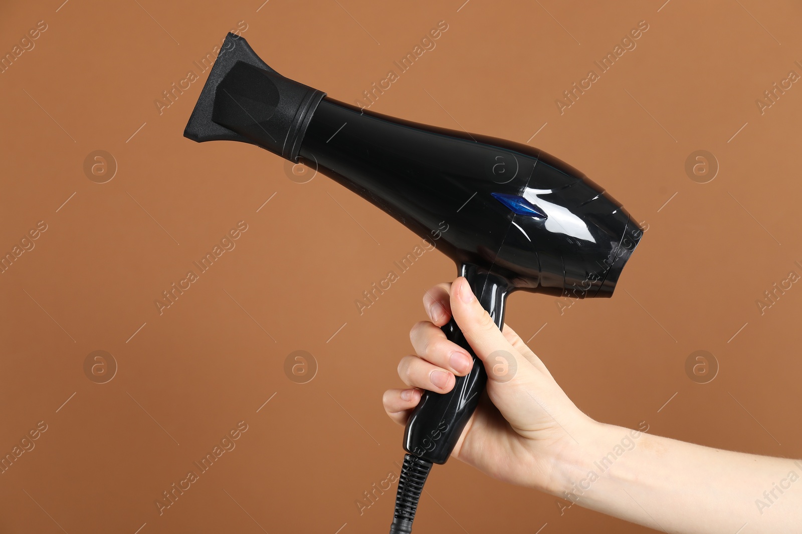 Woman with hair dryer on brown background, closeup Photo of Woman with hair dryer on brown background, closeup