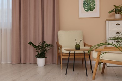 Photo of Stylish room interior with comfortable armchairs and beautiful window curtains