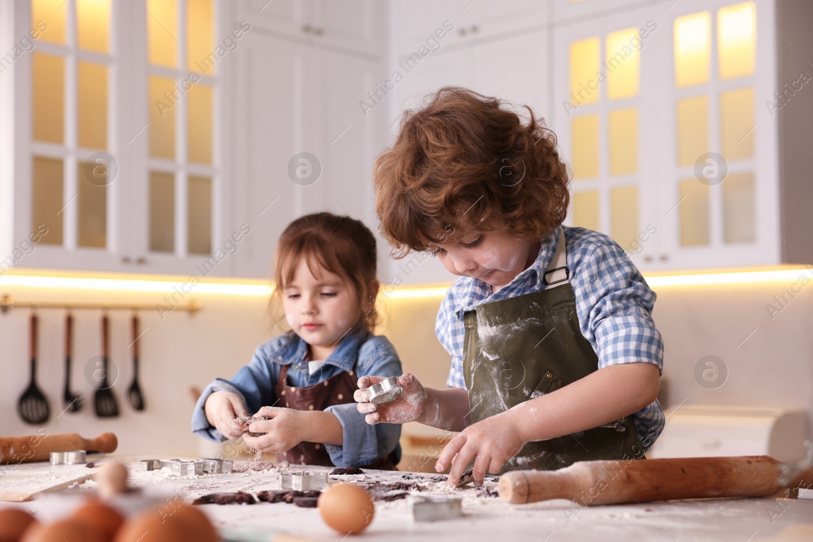 Cooking recipe. Little children making dough for cookies at table in kitchen Photo of Cooking recipe. Little children making dough for cookies at table in kitchen