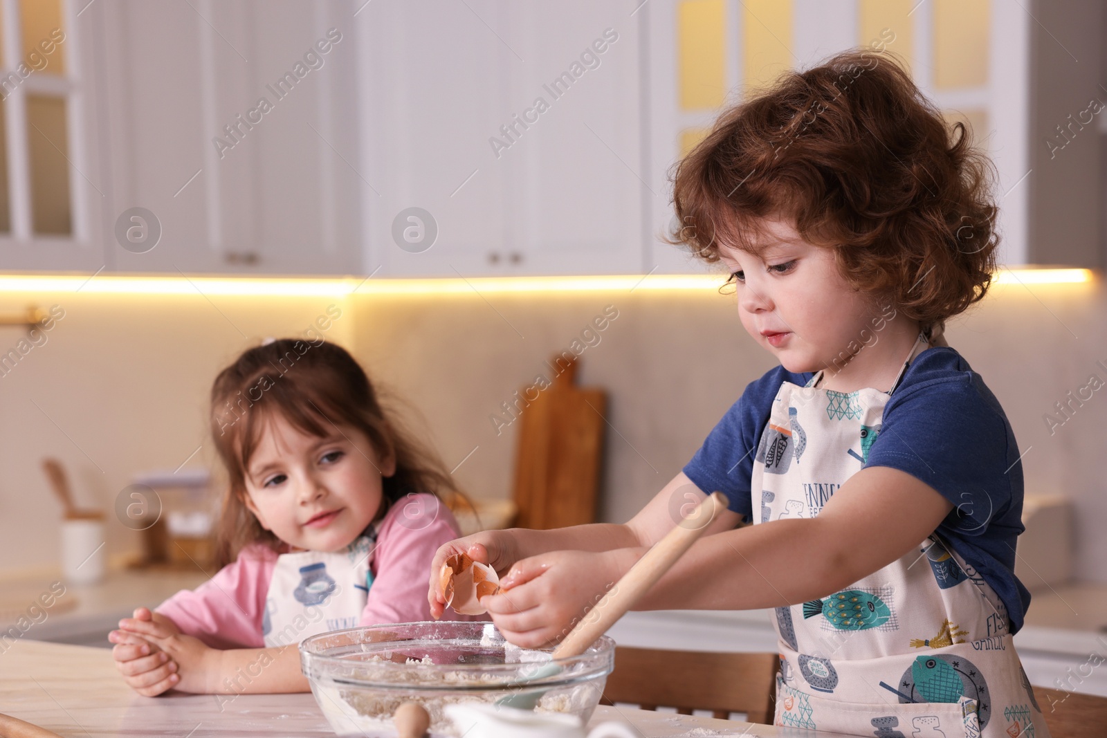 Cooking recipe. Cute children making dough for cookies at table in kitchen Photo of Cooking recipe. Cute children making dough for cookies at table in kitchen