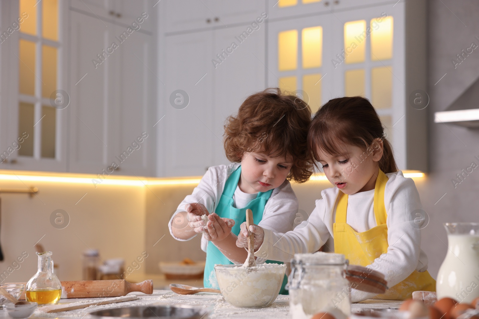 Cooking recipe. Cute children making dough for cookies at table in kitchen. Space for text Photo of Cooking recipe. Cute children making dough for cookies at table in kitchen. Space for text