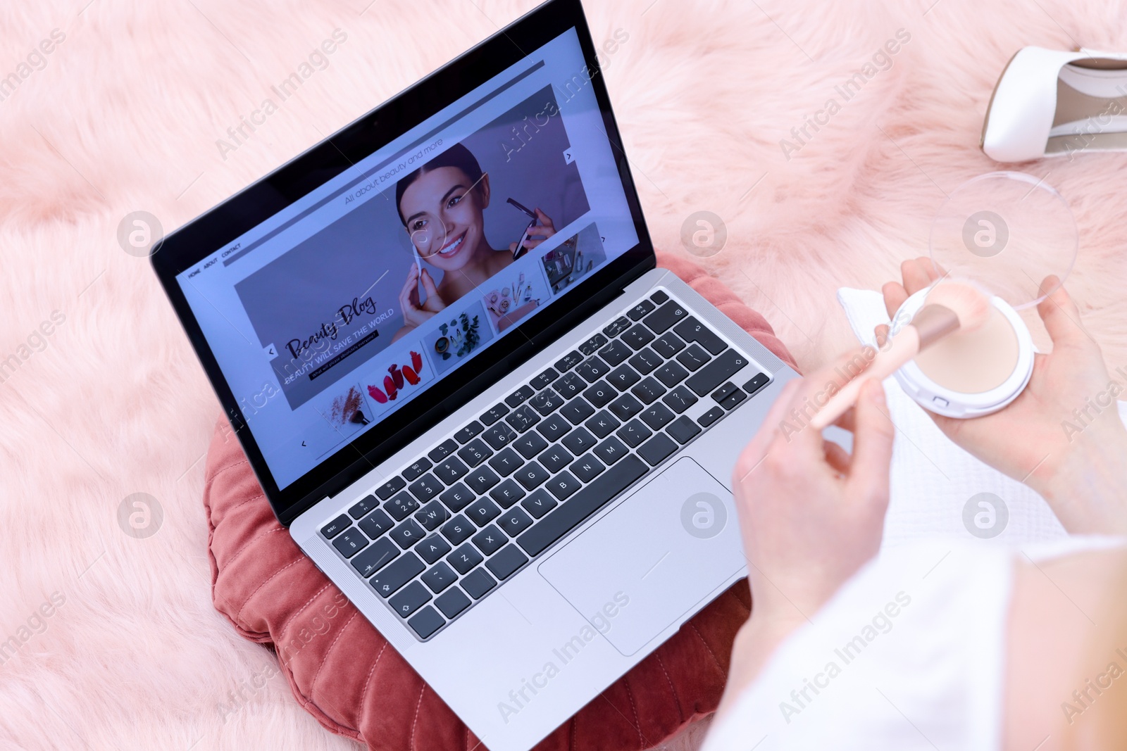 Beauty blogger with face powder and brush near laptop on floor indoors, above view Photo of Beauty blogger with face powder and brush near laptop on floor indoors, above view