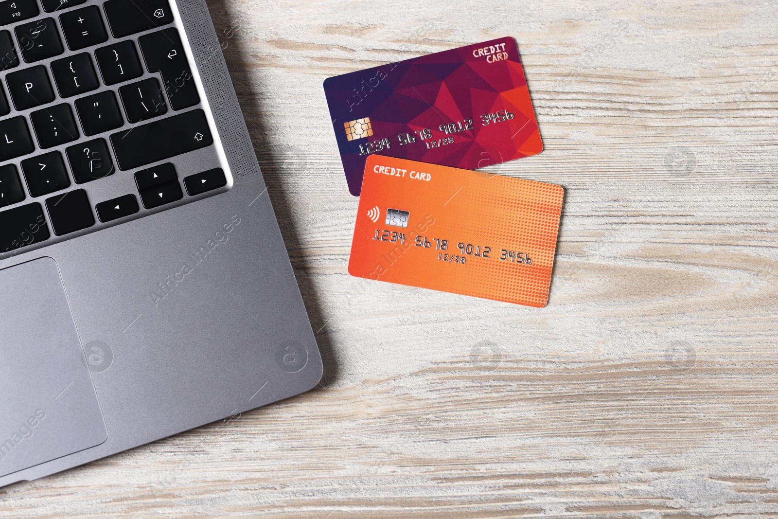 Online payment. Credit cards, cup of tea and laptop on grey wooden table, flat lay Photo of Online payment. Credit cards, cup of tea and laptop on grey wooden table, flat lay