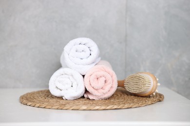 Photo of Clean towels and brush on white table indoors