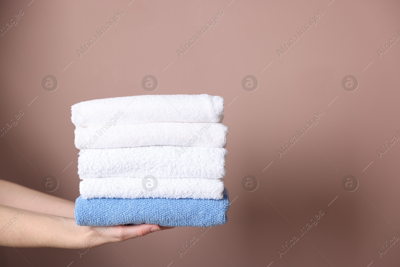 Woman with clean towels on beige background, closeup. Space for text Photo of Woman with clean towels on beige background, closeup. Space for text